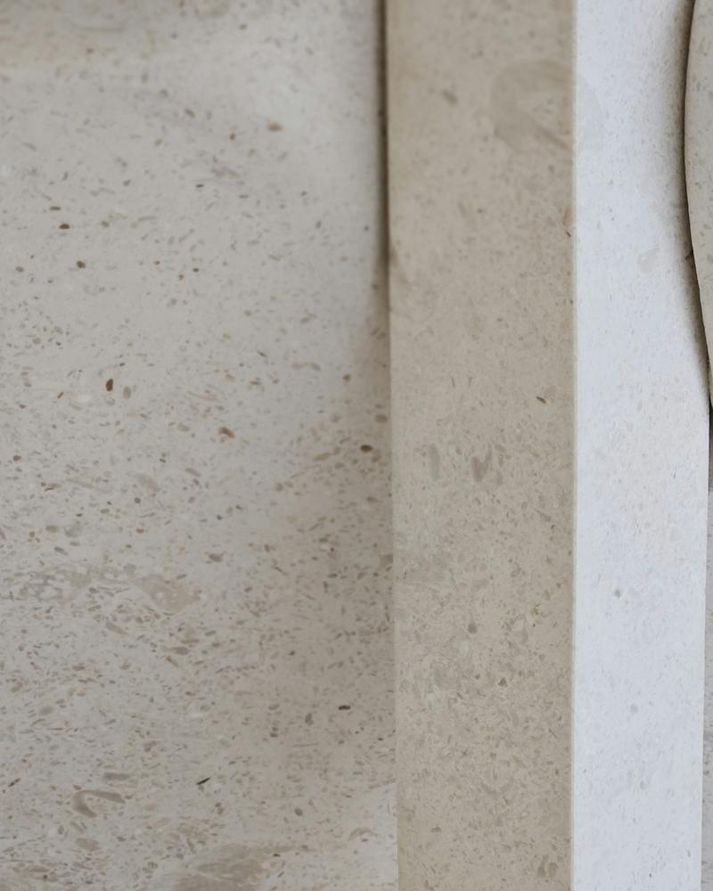 Pale honed limestone with a crisp stepped edge catching soft light