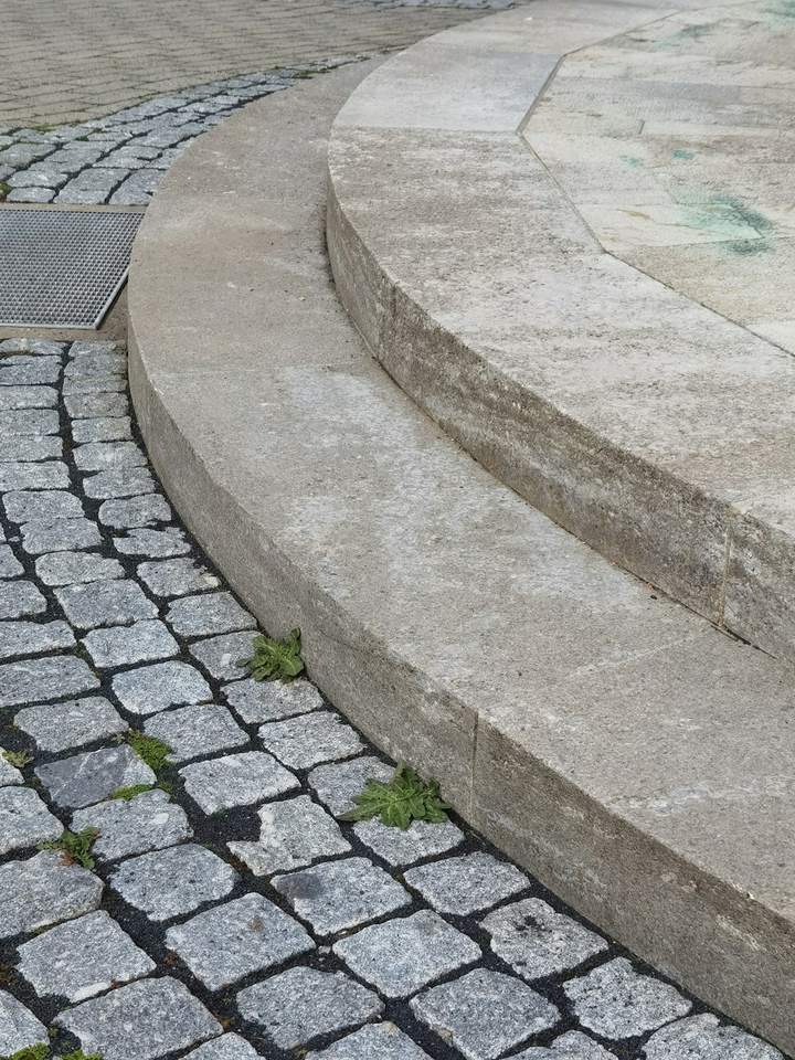 Curved stone steps rising beside a granite sett path