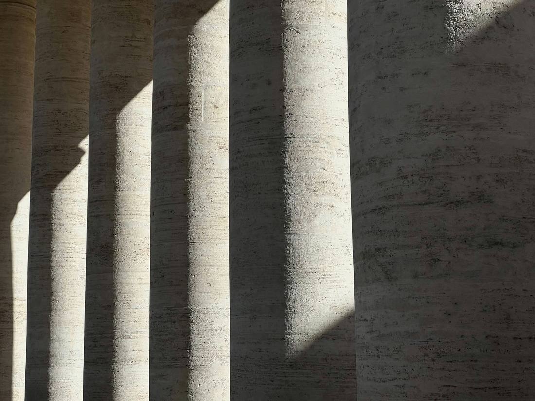 Light falling across a row of pale stone columns